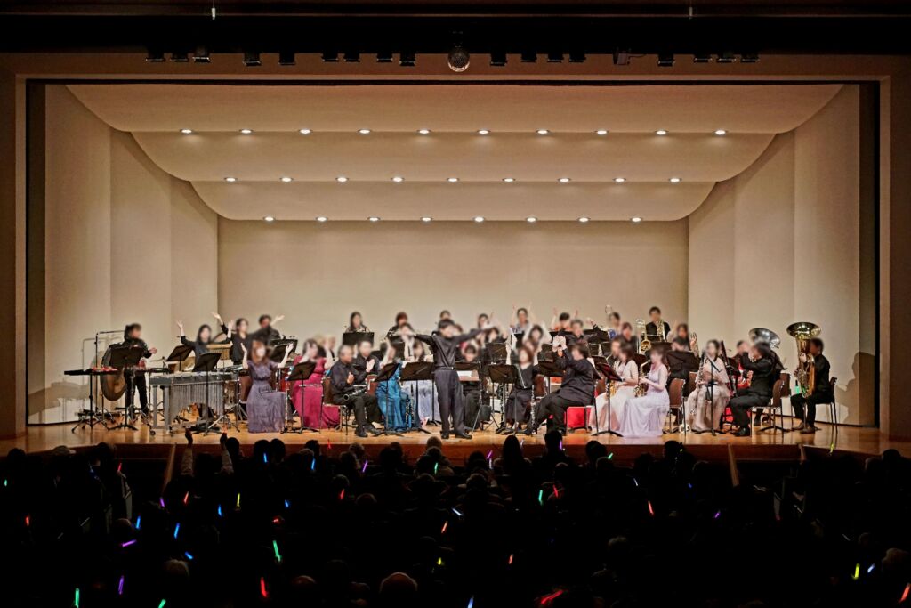 Marble Wind Brass TOKYOの演奏会。客席のペンライトが光る中、団員が手を挙げて客席と一緒に盛り上がっている